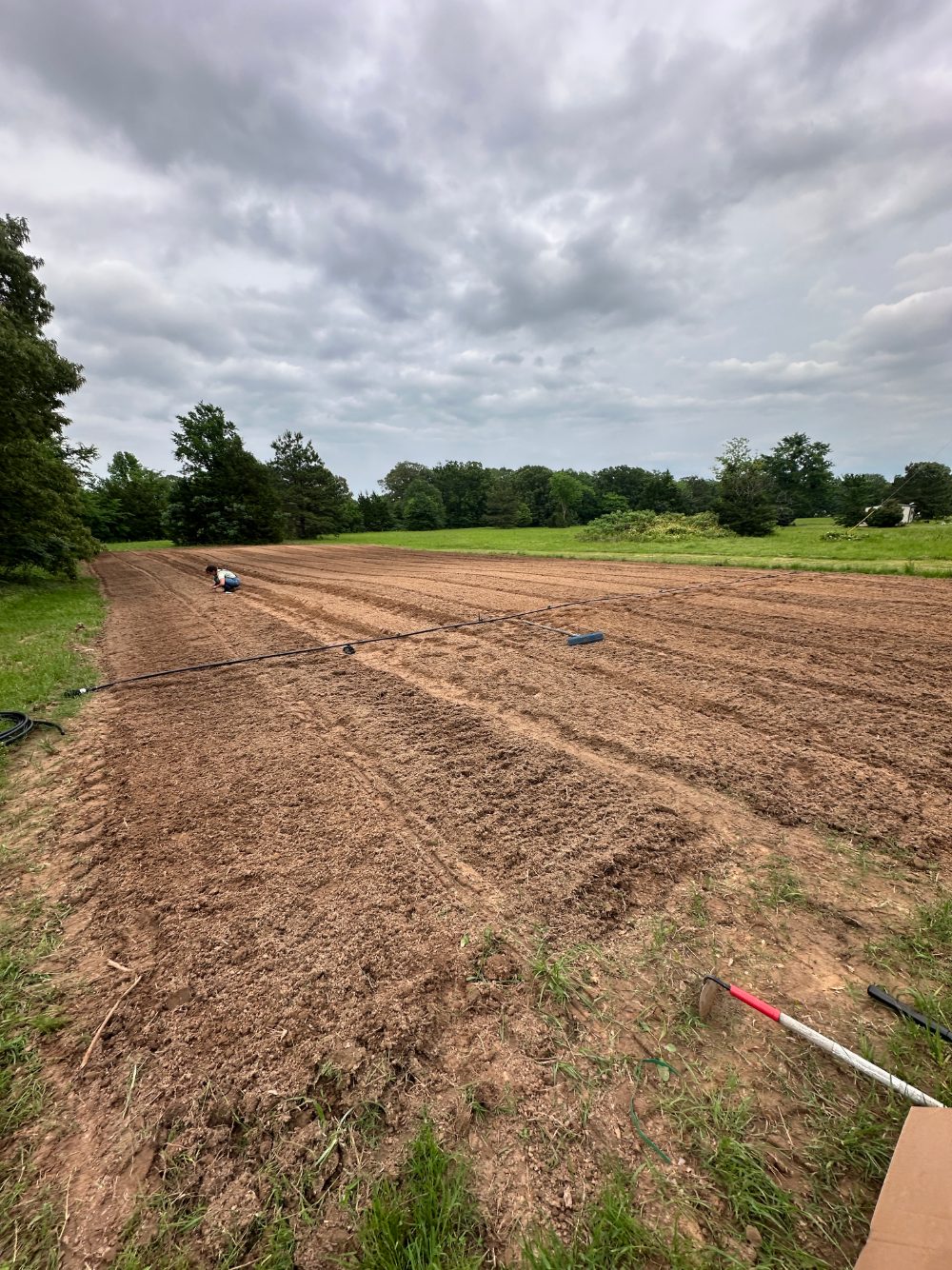 Freshly tilled field under cloudy spring sky